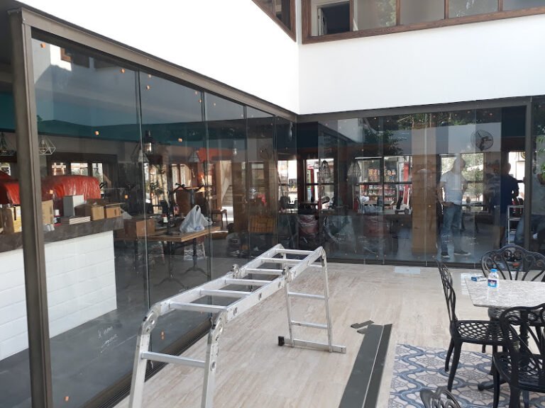 Sürme cam sistemiyle kapatılan kafe oturma alanı